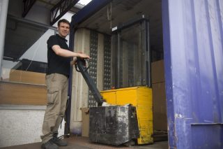 Mann mit elektrischer Gabelstapler

